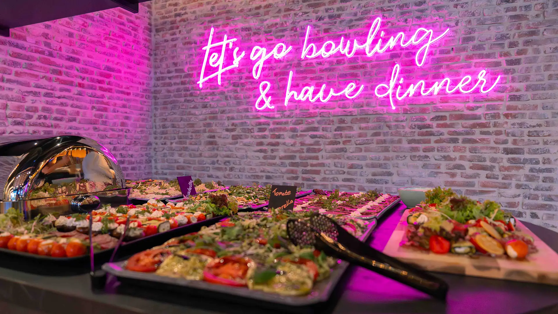 Buffet mit Neonschriftzug „let’s go bowling & have dinner“ bei Bowling 2000
