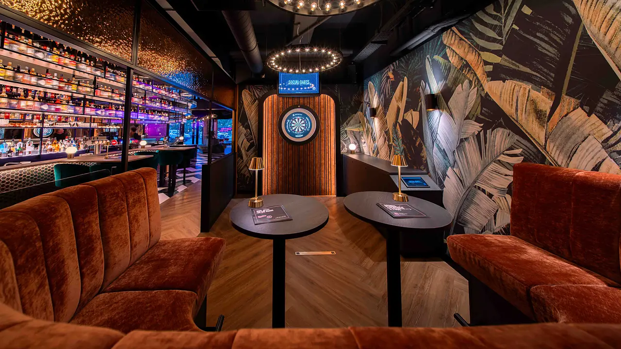 Social-Darts-Lounge mit Dartscheibe und Sofas